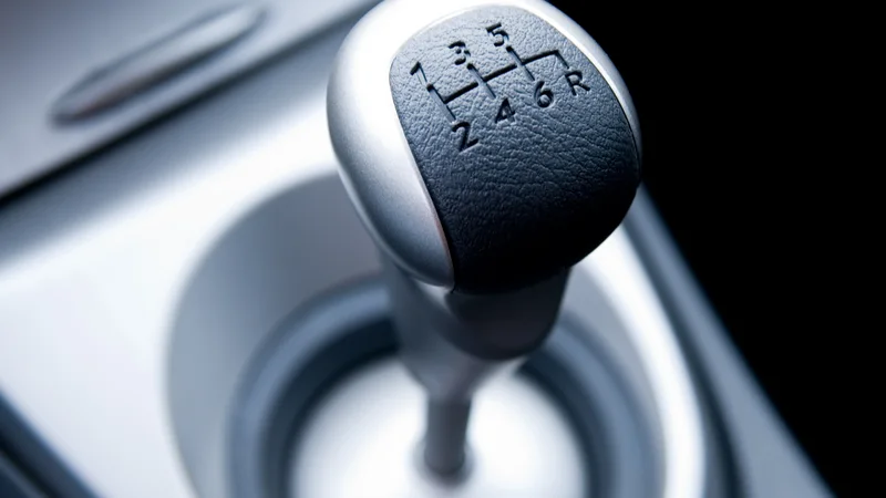 A manual gear selector in a car console, its shift pattern in relief